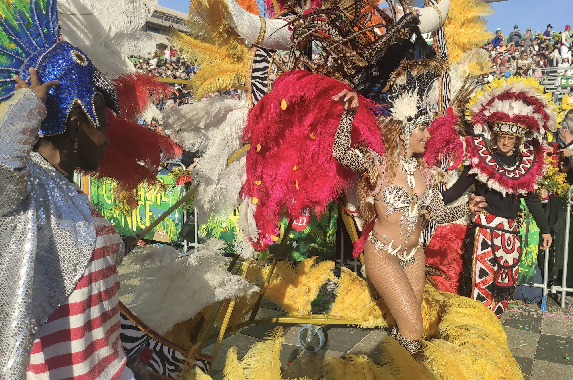 Le Carnaval des retrouvailles à Nice/ aufildeslieux.fr/ Danseuse aux plumes rouges-Bataille des fleurs© K.Hibbs