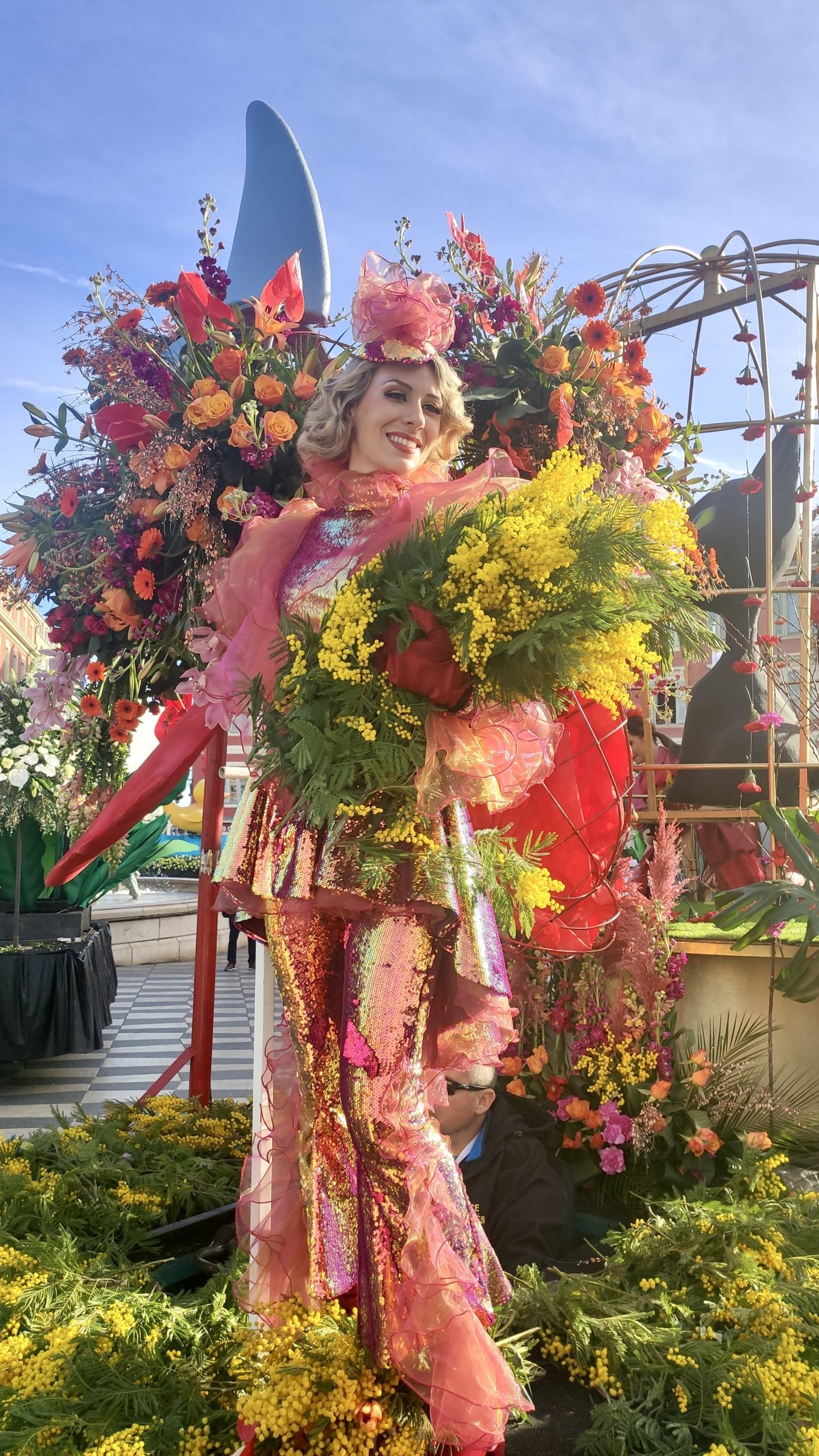 Le Carnaval des retrouvailles à Nice/ aufildeslieux.fr/Bataille des fleurs à Nice-Jeune femme aux mimosas© K.Hibbs