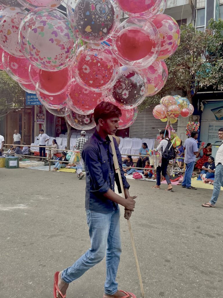 La plus belle larme de Bouddha/www.aufildeslieux.fr/ Marchand de ballons dans une rue de Kandy- Photo © K.HIBBS