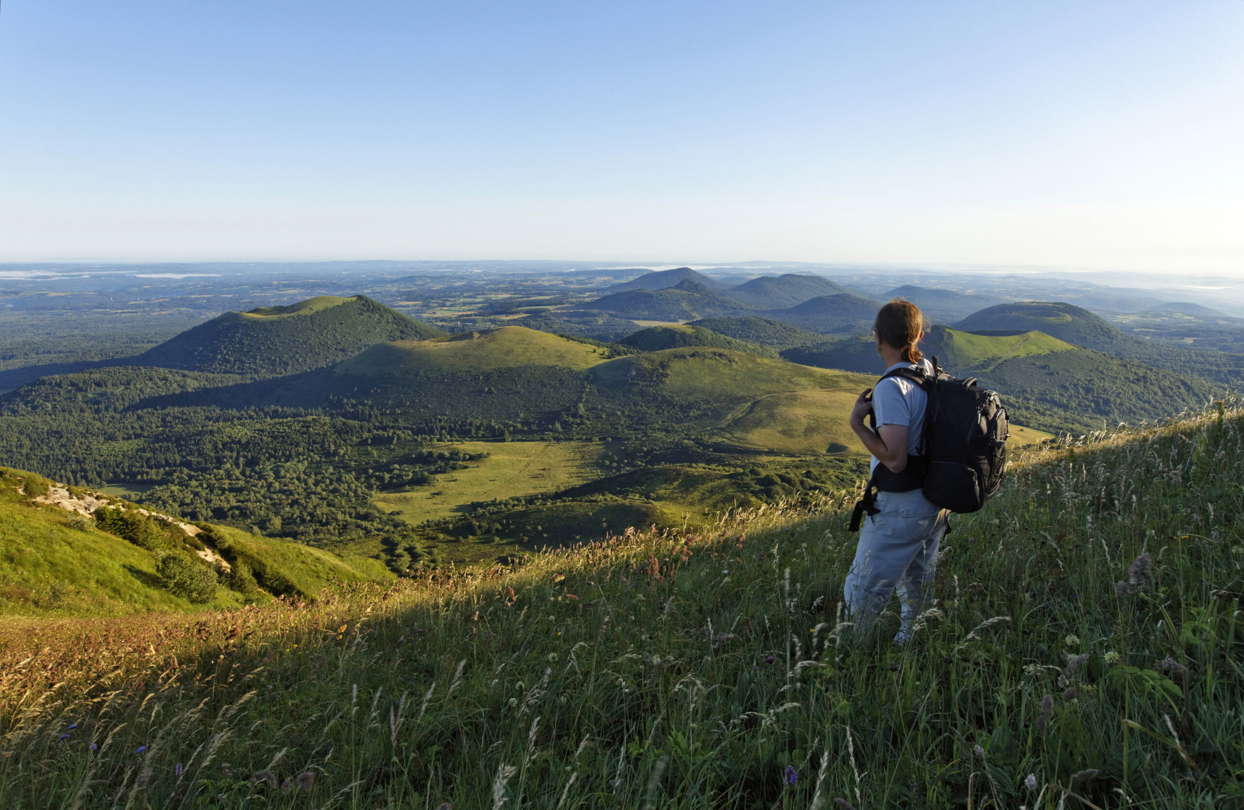 Clermont-Ferrand, entre volcans et patrimoine historique-www.aufildeslieux.fr/France, Puy-de-Dôme (63), zone classée Patrimoine Mondial de l'UNESCO, Parc Naturel Régional des Volcans d'Auvergne, randonneur au sommet du puy de DômeFrance, Puy-de-Dôme (63), Clermont-Ferrand, panorama depuis la cathédrale Notre-Dame-de-l'Assomption© Clermont Auvergne Tourisme