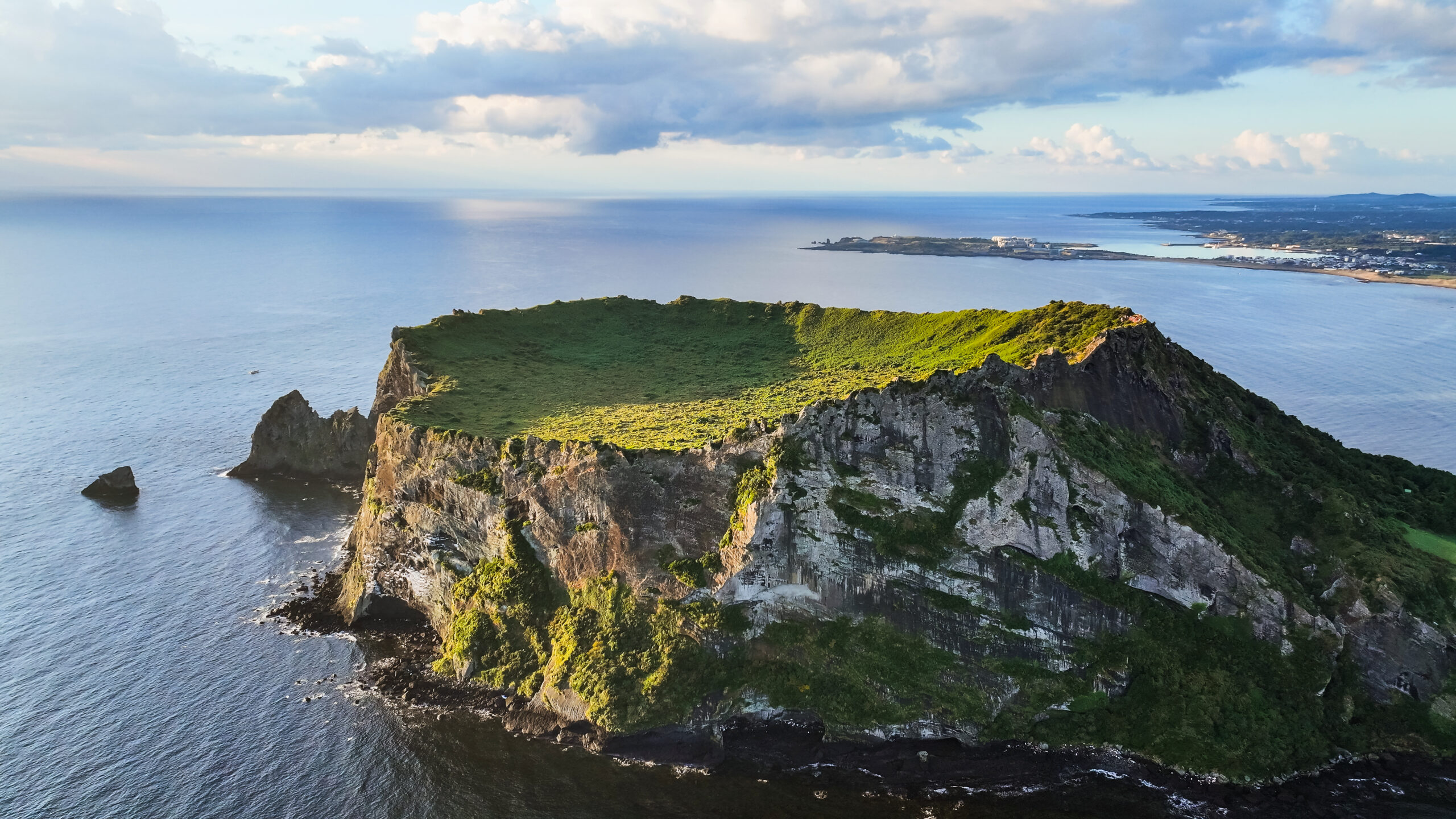 Les Haenyeo, gardiennes de la mer/ www.aufildeslieux.fr/Le pic volcanique SEONGSAN ILCHULBONG à l'est de l'île de Jeju © DR